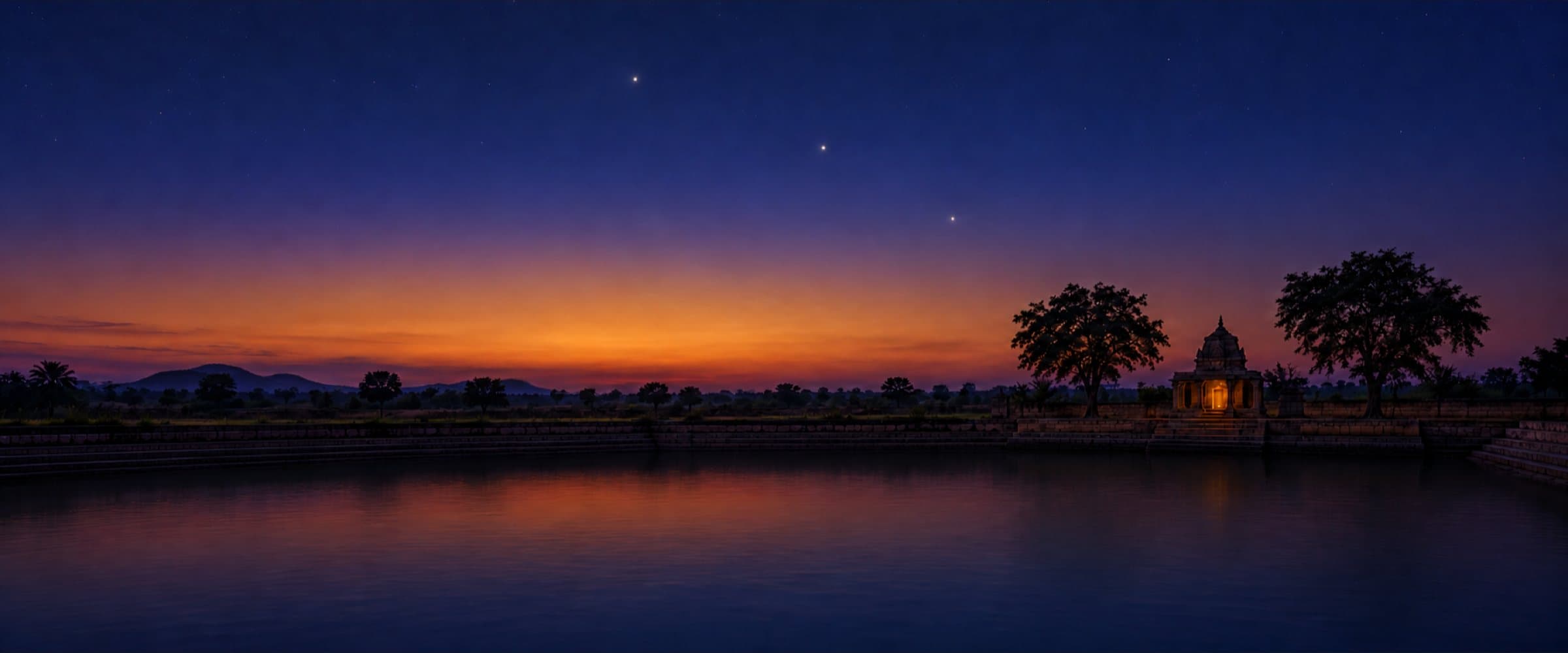 Three bright planets in the blue-hour sky over a temple tank in India
